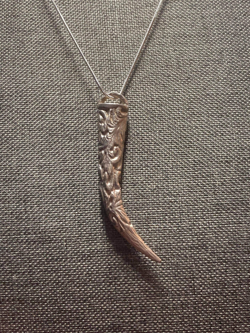 Scroll work wolf tooth pendant.