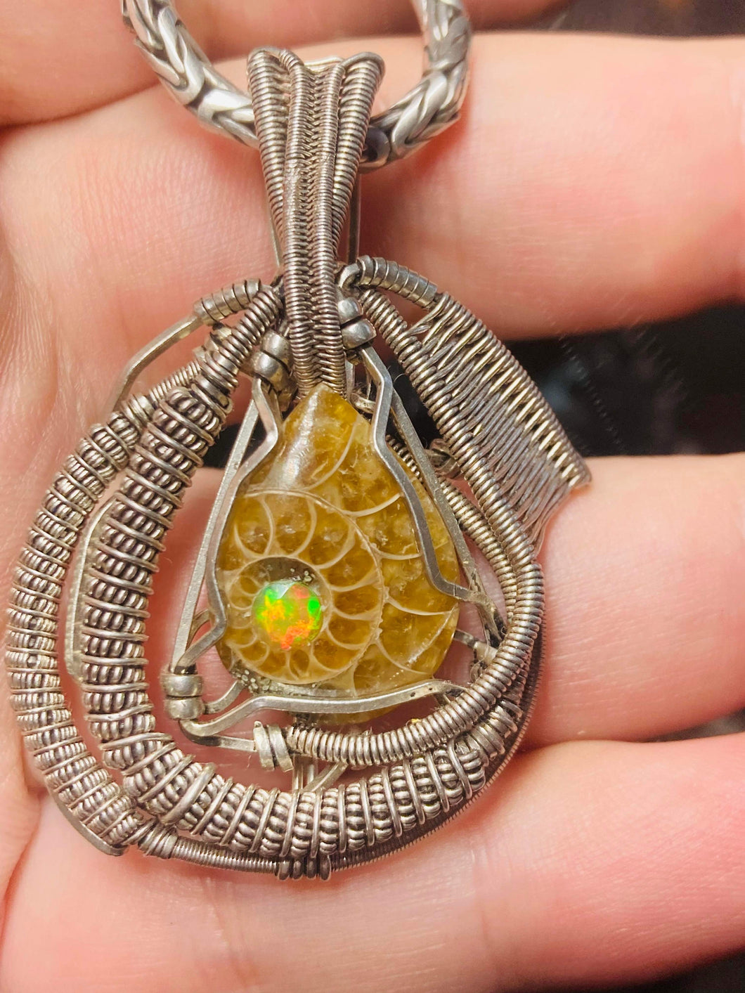 Faceted Ethiopian Opal set into an ammonite fossil cabochon wire wrapped in sterling .925