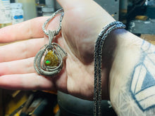 Load image into Gallery viewer, Faceted Ethiopian Opal set into an ammonite fossil cabochon wire wrapped in sterling .925

